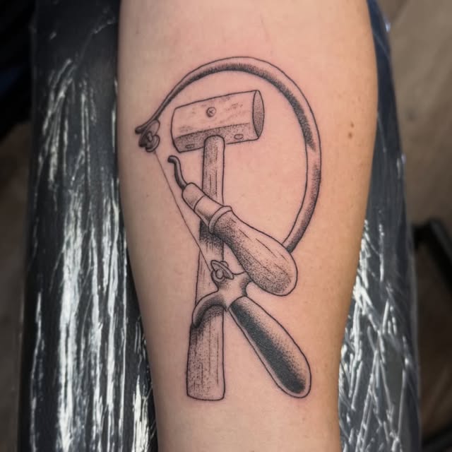 Black and grey hammer and sickle tattoo on forearm, Baton Rouge