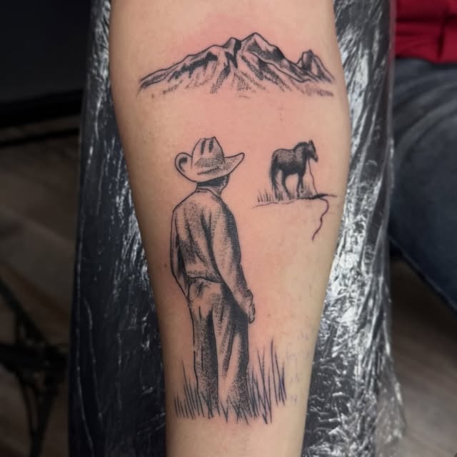 Fine line cowboy and horse mountain scene tattoo on forearm, Baton Rouge