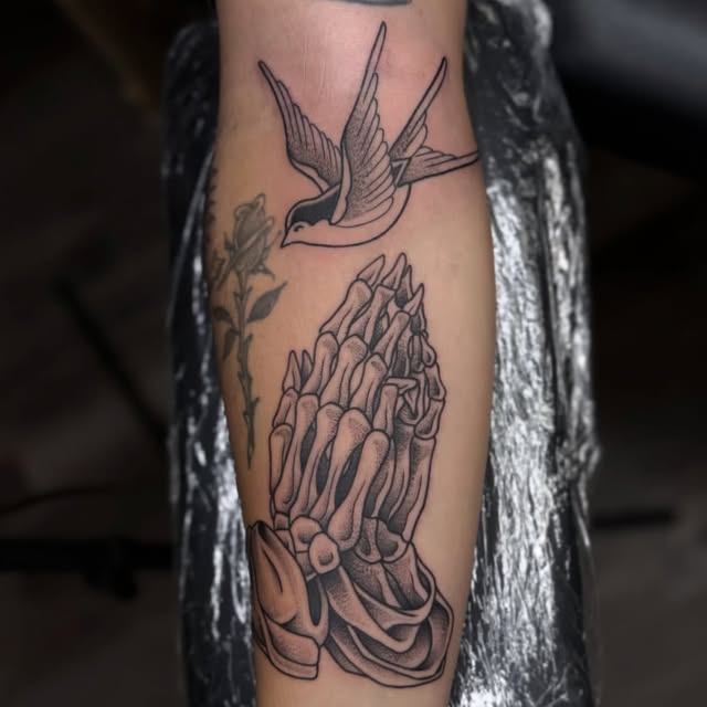 Black and grey swallow and praying hands tattoo on forearm, Baton Rouge